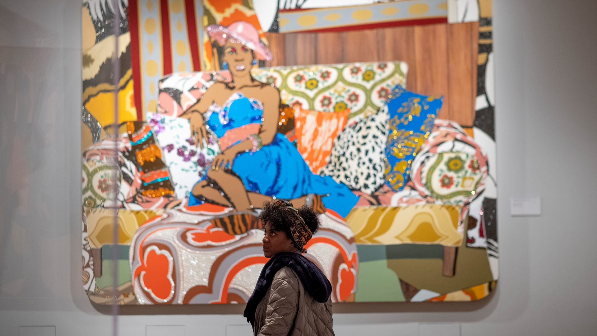 A visitor standing in front of "Something You Can Feel" by Mickalene Thomas