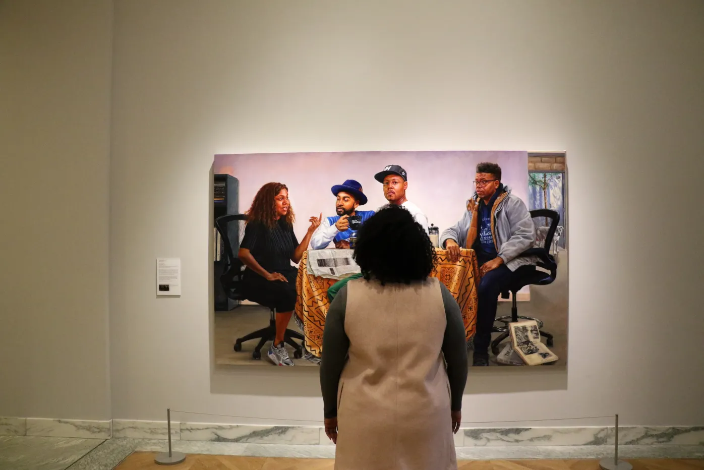 A visitor observes Mario Moore's "The Council," in the Detroit Institute of Arts' galleries.