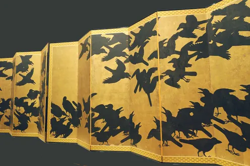 A long, unfolded yellow paper printed with swarms of black birds. 